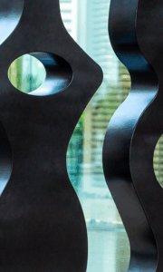 A stylish and sleek abstract sculpture with a dark, metallic finish, suitable for themes of modern art, architecture, and interior design.