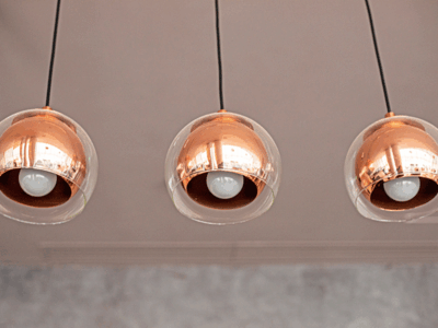 three modern, rose-metallic lamps hanging from the ceiling.