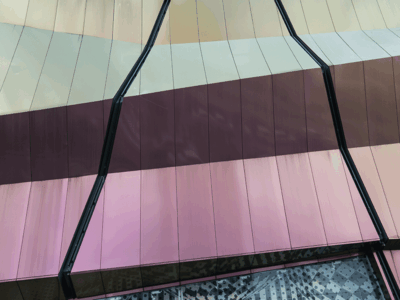 Facade with vertically segmented metallic panels in soft beige, bronze, and pink tones, creating a reflective, folded surface structure.